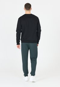 VIRTUS Verryttelyhousut - dusty forest