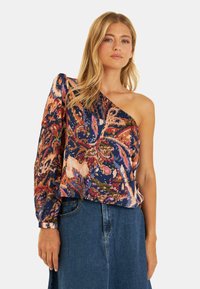 Bloemmotief, een-schouder blouse in marineblauw, roze en oranje. Heeft een losse pasvorm met lange ballonsleeve en textiele stof.