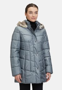 Manteau en duvet gris avec capuche doublée de fourrure, design en losanges, boutons-pression et manches longues, présentant une coupe décontractée et une longueur mi-cuisse.