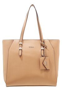 Sac fourre-tout synthétique beige avec poignées doubles, présentant des bords géométriques, une étiquette en métal et un logo de la marque embossé à l'avant.
