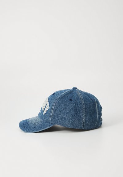 Boné de basebol em denim com aba curva, na cor azul, e lettering branco bordado na frente. Apresenta um design de seis painéis e uma alça ajustável.