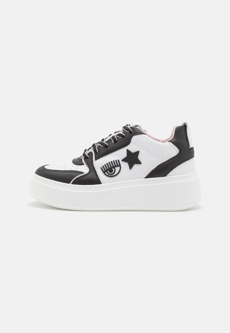 Sneakers platform in bianco e nero con design grafici di occhi e stelle, pelle testurizzata e suola in gomma bianca, dotati di lacci neri e interno rosa.