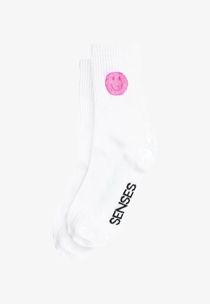 White cotton socks featuring a pink smiley face graphic and black "SENSES" text on the side, with ribbed texture and ankle length.