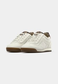 Άσπρα δερμάτινα παπούτσια τύπου σνίκερς με καφέ  λαστιχένιες σόλες, διακοσμητικές ραφές και λεπτομέρεια με μοτίβο λεοπάρ στο τακούνι. Κλείσιμο με επίπεδα κορδόνια.