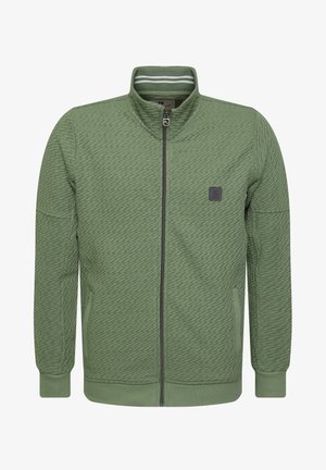 Suurendatud tõmblukuga jakki tumeroheline tekstuuriga kangas, millel on seisva krae, küljetaskud ja väike logoplaat rinnal. Kraele valged triibud.