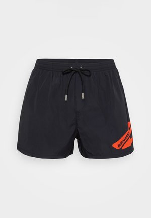 Bañador negro con cintura elástica y cordón negro, que presenta el logotipo rojo en ángulo "DSQUARED" en la pierna derecha.