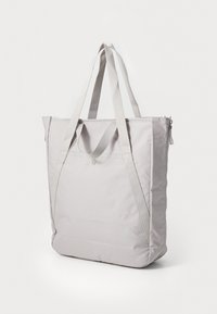 Sac fourre-tout en tissu gris avec deux poignées, une fermeture éclair et un design minimaliste. Présente des coutures renforcées et un fond plat pour plus de stabilité.
