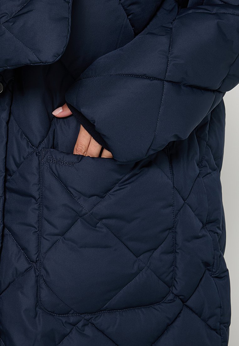 Granatowa pikowana kurtka puchowa z wzorem w diamenty, z boczną kieszenią z wytłoczonym napisem "Barbour" oraz ściągaczami przy rękawach dla dodatkowego ciepła.