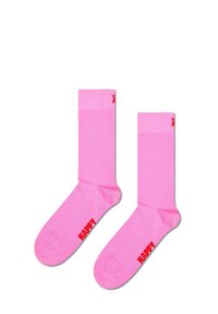 Calcetines rosas con el texto en rojo "HAPPY" en cada lado. De altura media, textura suave y diseño sin costuras.