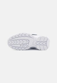 Semelle de sneaker en caoutchouc blanc avec un motif de grip texturé. Présente un logo FILA proéminent et un design de talon courbé pour un soutien amélioré.