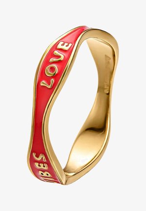 Anillo de oro con una banda ondulada que presenta una incrustación de esmalte rojo y letras doradas en relieve que forman la palabra "VIBES LOVE".