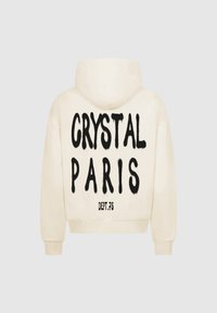 Hoodie color crema con una grande grafica nera che riporta la scritta "CRYSTAL PARIS" sul retro e "DEPT.75" sotto. Presenta una tasca frontale a marsupio e cappuccio.