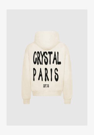 Kremowa bluza z kapturem z dużym czarnym nadrukiem na plecach, na którym widnieje napis "CRYSTAL PARIS" oraz "DEPT.75" poniżej. Posiada przednią kieszeń typu kangur oraz kaptur.