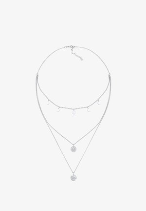 Collier en chaîne argentée à triple couche avec cinq petits charms ronds sur la couche supérieure et deux pendentifs circulaires gravés sur les couches inférieures.