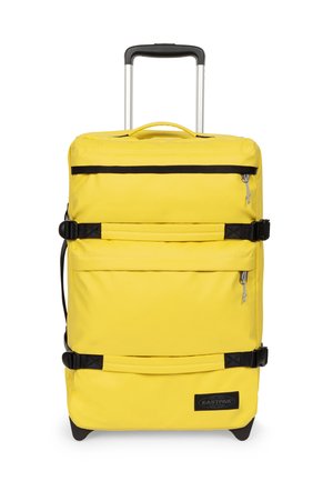 Maleta amarilla brillante con ruedas, asa telescópica, dos bolsillos frontales con cremallera, tiras de compresión laterales y parche con el logo negro de Eastpak.