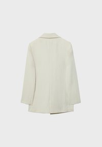 Blazer écru à manches longues avec col cranté, vu de dos sur un fond clair uni.