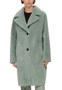 Manteau duveteux vert menthe avec un col à crans, coupe droite à simple boutonnage, deux poches latérales et boutons noirs. Confectionné dans un matériau doux et texturé.