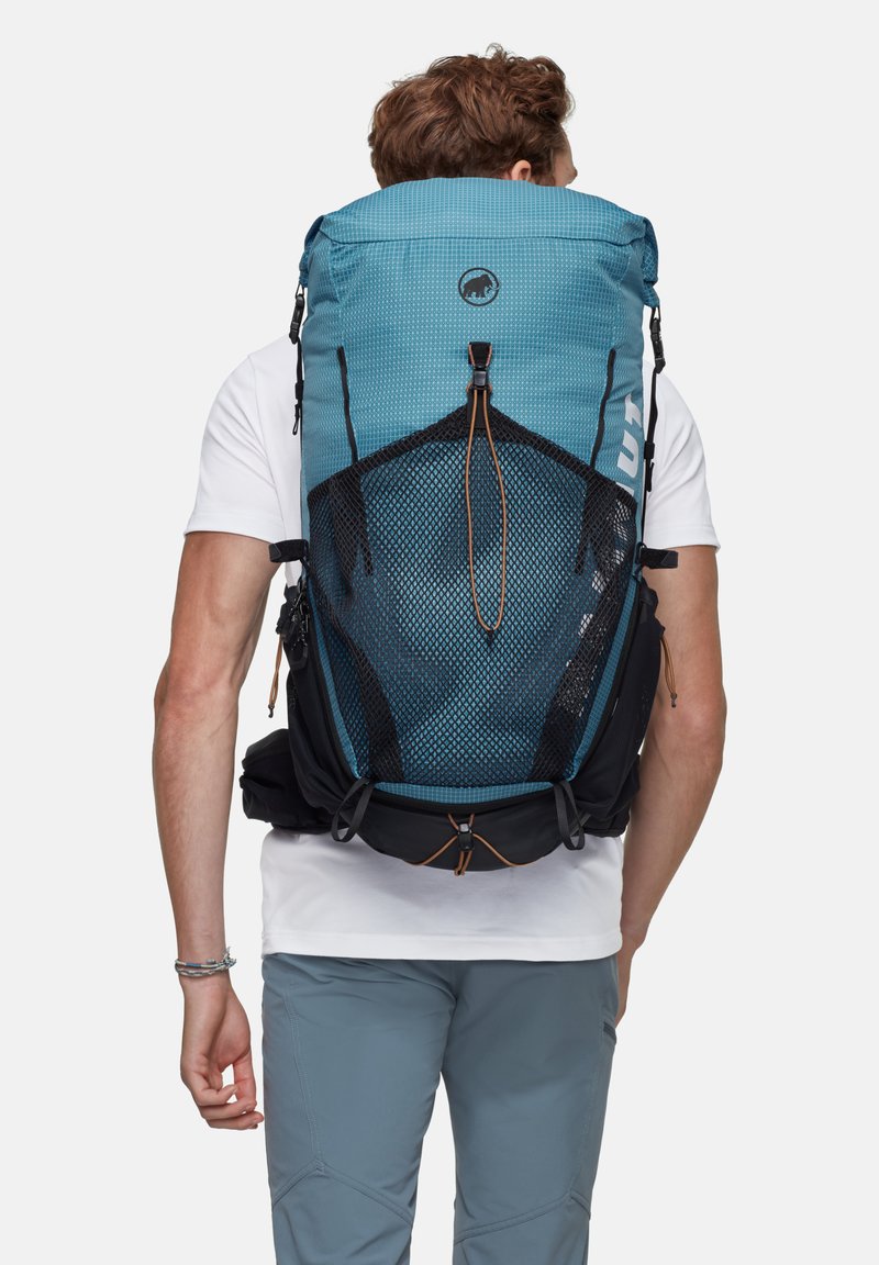 Blå och svart ryggsäck med meshnät på baksidan, justerbara axelremmar och en övre dragsko. Texturerad tyg med en logotypdetalj.