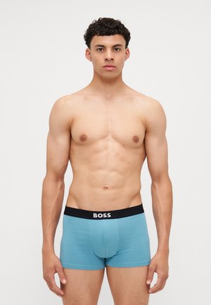 Boxeri scurți din bumbac albastru cu un brâu elastic negru pe care este inscripționat logo-ul "BOSS" în alb. Textură netedă, design ajustat.
