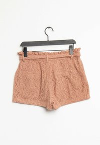 Krajkové šortky v jemně růžové barvě s volánkovým pasem, dvěma zadními kapsami a květinovým vzorem na celém materiálu.