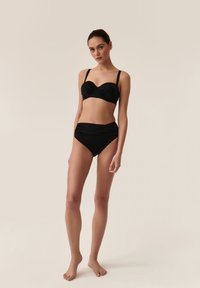 Black bikini set featuring a padded, gathered bandeau top with thin straps and high-waisted bottom. Smooth texture and minimal design.