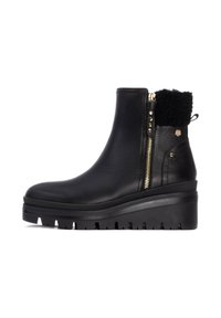 Botas negras de tobillo con parte superior texturizada, acento de cremallera dorada y suela de cuña gruesa. Presenta un cuello forrado de piel y tachuelas decorativas.