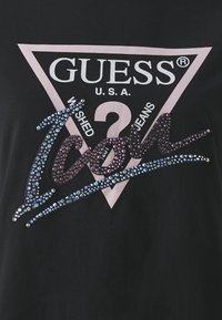 Sort t-shirt med et pink trekantsdesign og teksten "GUESS® U.S.A.", forskyndet med iriserende rhinsten og en stiliseret "Icon" skrift.
