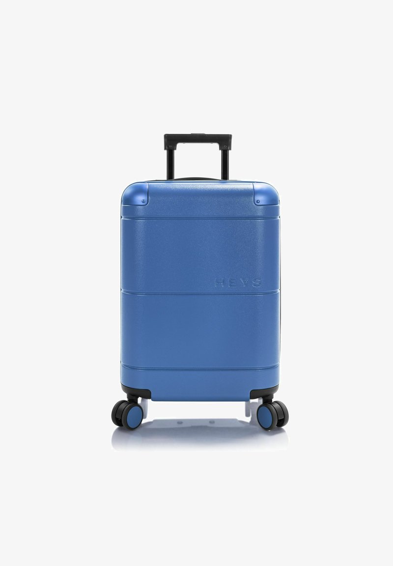 Valise rigide bleue avec une finition texturée, deux roulettes lisses, une poignée télescopique et un logo de la marque en relief à l'avant.