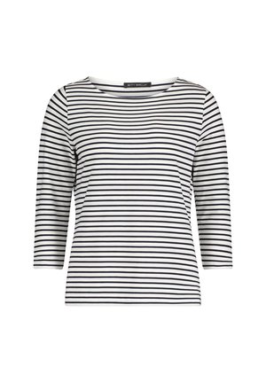 Pasiasty top z 3/4 rękawami w kolorze białym i czarnym, z szerokim dekoltem typu łódka i dopasowaną sylwetką, wykonany z miękkiego, elastycznego materiału.