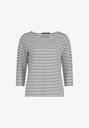 Pasiasty top z 3/4 rękawami w kolorze białym i czarnym, z szerokim dekoltem typu łódka i dopasowaną sylwetką, wykonany z miękkiego, elastycznego materiału.