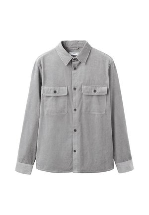 Harmaa corduroy-paita, jossa on kärkipäinen kaulus, pitkät hihat, kaksi rintataskua ja napitettava etuosan suljenta. Paitaa koristaa pystysuuntainen ribbineulos.