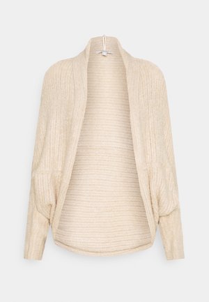 Kermanvärinen ribbineulottu avoin neuletakki, jossa pitkät hihat ja liehuva kaulus, esillä yksiväristä taustaa vasten.