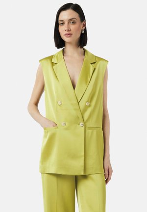 Limoengroene tweedelige mouwloze blazer met een diepe V-hals, twee voorzakken en witte knopen, gemaakt van glad satijnen stof.
