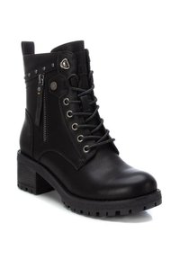 Stivale ankle in pelle nera con lacci sul davanti, zip laterale, accessori in argento, suola texturizzata e tacco impilato.