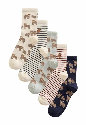 Five pairs of mid-calf socks in cream, navy, and gray with alternating stripes and cartoon cow patterns arranged in a fanned-out display.