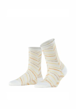 Para skarpetek sięgających do połowy łydki o białej bazie z nieregularnym wzorem pomarańczowych i żółtych pasków, prezentowana pionowo na jednolitym białym tle.