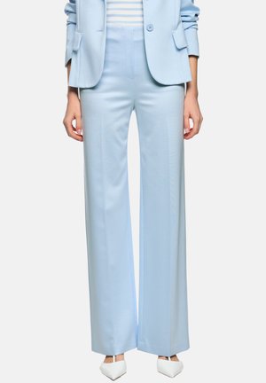 Light blue high-waist wide-leg pants paired with a matching blazer and white pointed-toe heels, worn over a striped top.