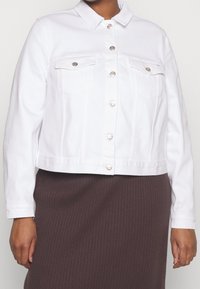 Weiße Denimjacke mit Kragen, silberner Knopfleiste, zwei Brusttaschen und langen Ärmeln; verfügt über ein kurzes Design.