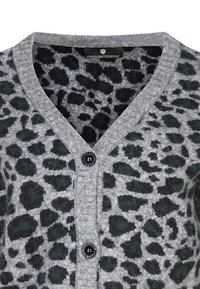 Cardigan gris avec un imprimé léopard en vert foncé et noir. Design en V avec un seul bouton noir au centre. Texture douce.