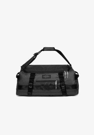 Sort duffelbag fremstillet af slidstærkt stof, justerbar skulderrem, to lynlås lommer og vævbånd detaljer for ekstra støtte.