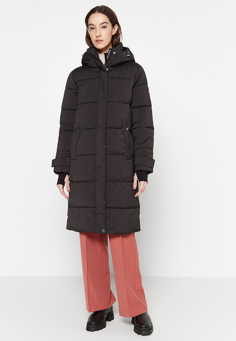 Schwarze Puffermantel mit knielangem Design, ausgestattet mit Kapuze, gerippten Bündchen und zwei Seitentaschen. Glattes, leichtes Material mit gestepptem Muster.