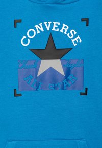 Felpa blu con cappuccio caratterizzata da una grafica a stella nera, testo bianco "CONVERSE" e accenti blu con "Chuck Taylor" e "ALL STAR" in un design a strati.