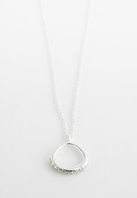 Collier en pendentif argenté en forme de goutte d'eau avec une rangée de petites pierres transparentes d'un côté. Il est doté d'une chaîne délicate.