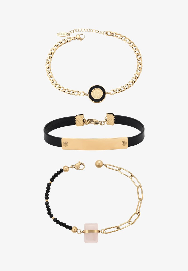 Trzy bransoletki: złoty łańcuszek z czarnym okrągłym medalionem, czarny skórzany pasek ze złotą plakietką oraz mieszany złoty łańcuszek z czarnymi koralikami i różowym kamieniem.