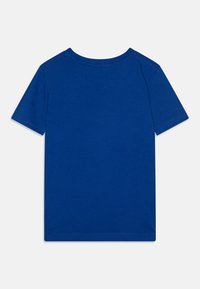 Kortermet blå T-skjorte laget av bomull. Har rund hals og ensfarget tekstur uten ekstra mønstre eller design.