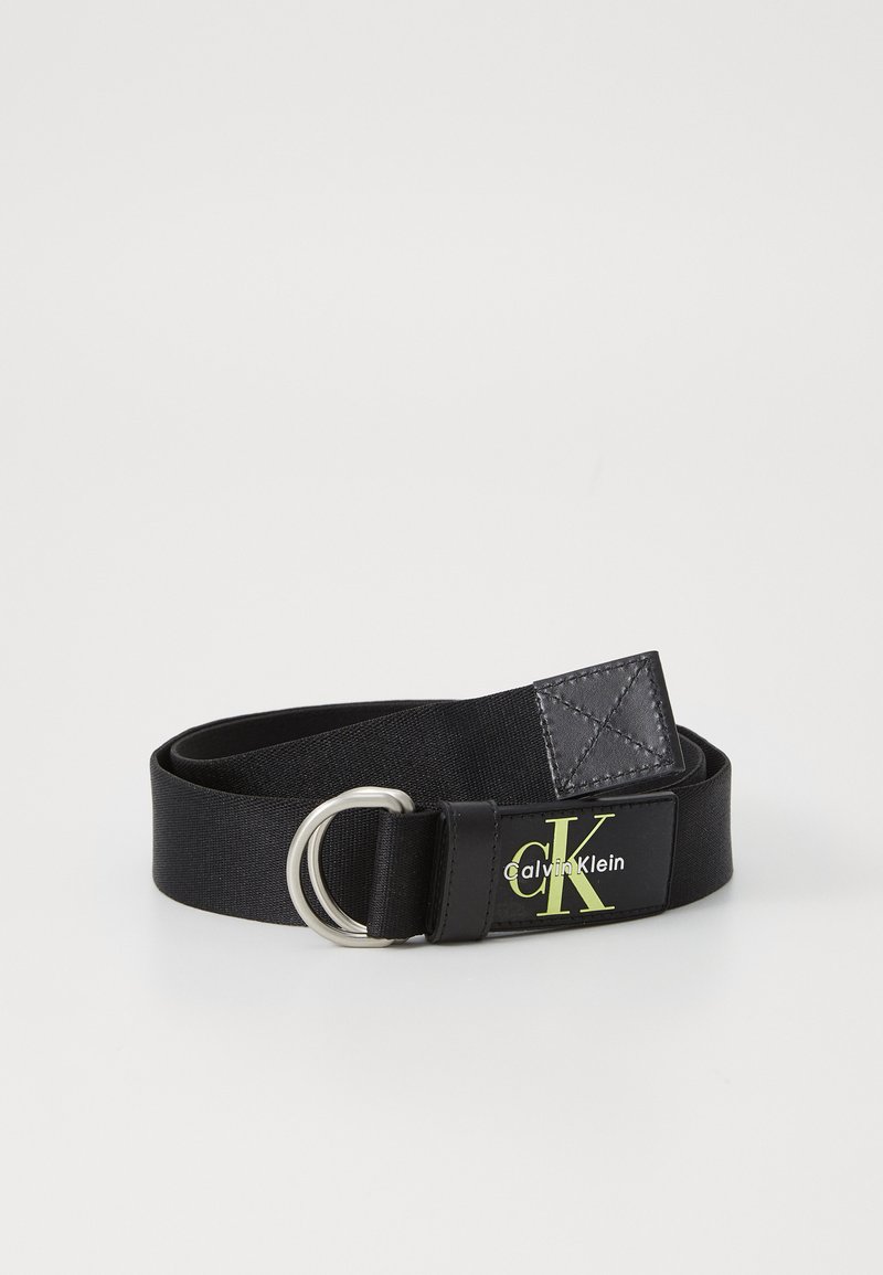 Black fabric belt with a silver metal D-ring buckle. Features a black leather patch with a green logo and white text on one side.