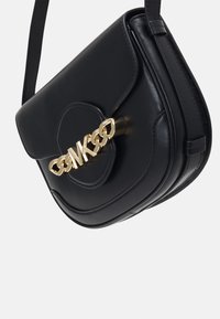 Sac à bandoulière en cuir noir avec une forme arrondie, mettant en avant une fermeture en chaîne dorée et des détails de couture subtils à l'avant.
