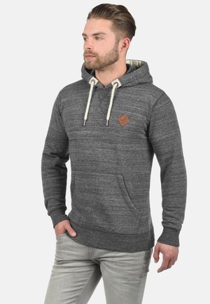 Grijze hoodie van een gestructureerde stof, met een kangoeroezak, trekkoorden en een klein bruin logo-op-patch op de borst. De hoodie heeft een zachte binnenvoering.