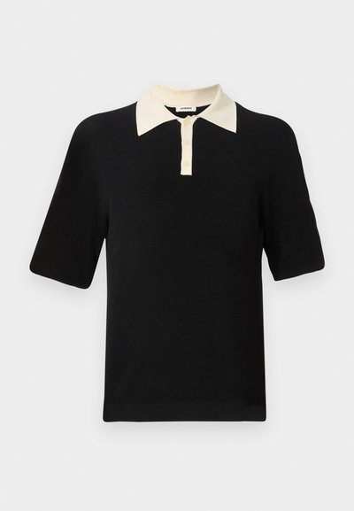 Μαύρο πόλο με κοντά μανίκια, κρεμ γιακά και τρία κρεμ κουμπιά στην μπροστινή πατιλέτα.