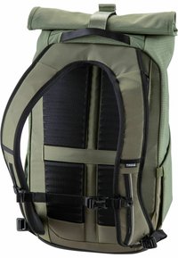 Sac à dos vert à rabat, avec un panneau arrière en maille noire texturée, des bretelles réglables et des boucles latérales pour une fermeture sécurisée. Étiquette de marque visible.